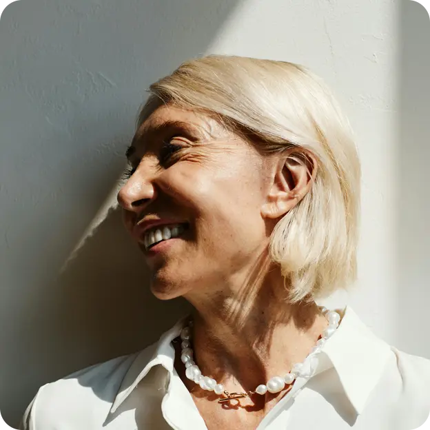 A woman is laughing an looking to the left