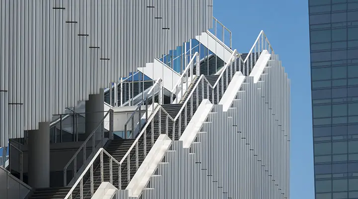 Metalen trap langs de gevel van een modern kantoorgebouw.
