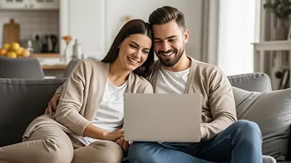 Ein Mann und eine Frau schauen sich etwas auf dem Laptop an.