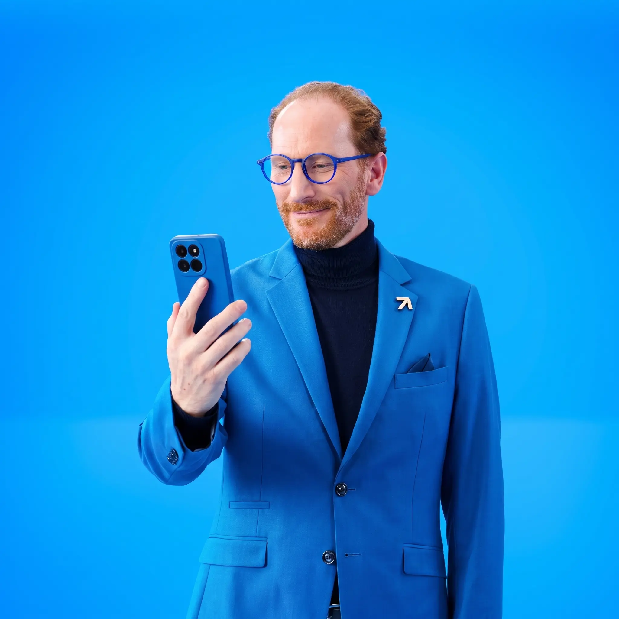 Spokesperson wearing a blue suit looking down at his smartphone screen against a bright blue background.