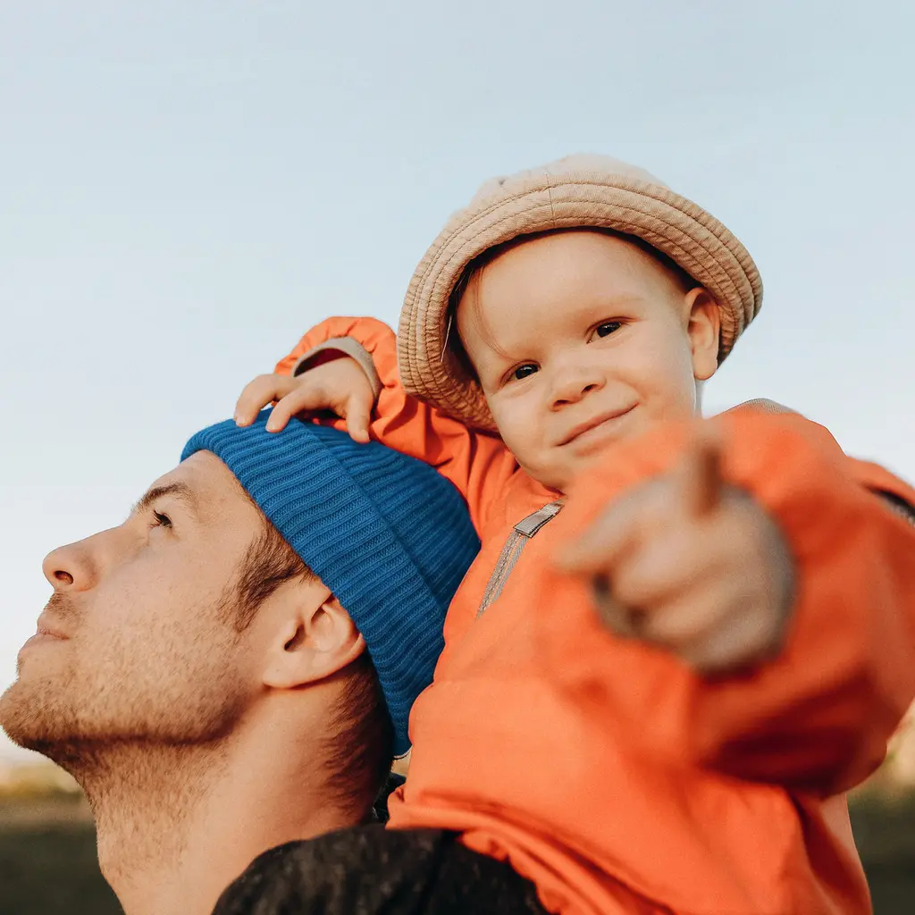 Un père portant son jeune enfant sur ses épaules
