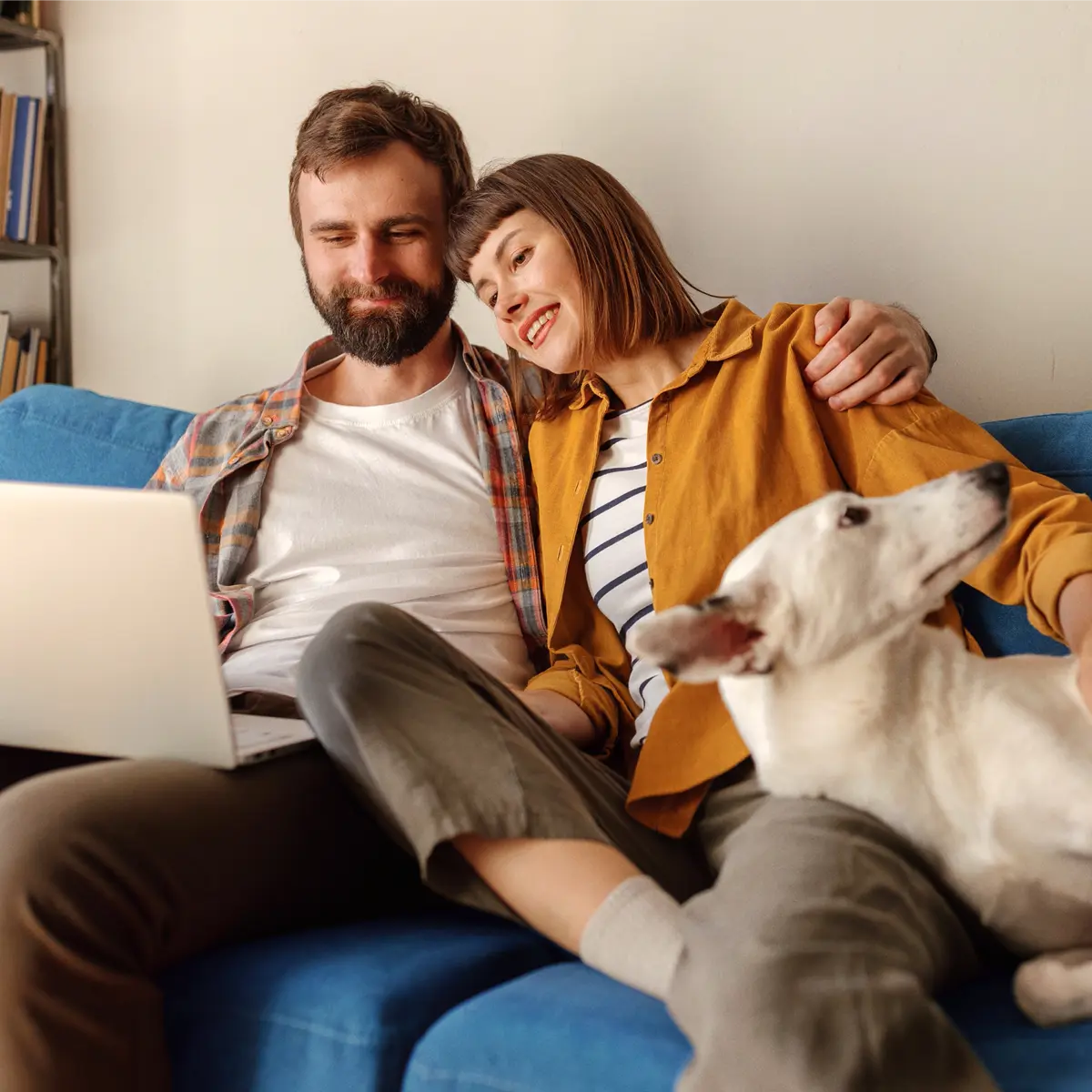 Raisin DE-paar_laptop_gemeinsames_vorsorgen.jpg Junges Paar sitzt mit Hund auf dem Sofa und nutzt gemeinsam einen Laptop.