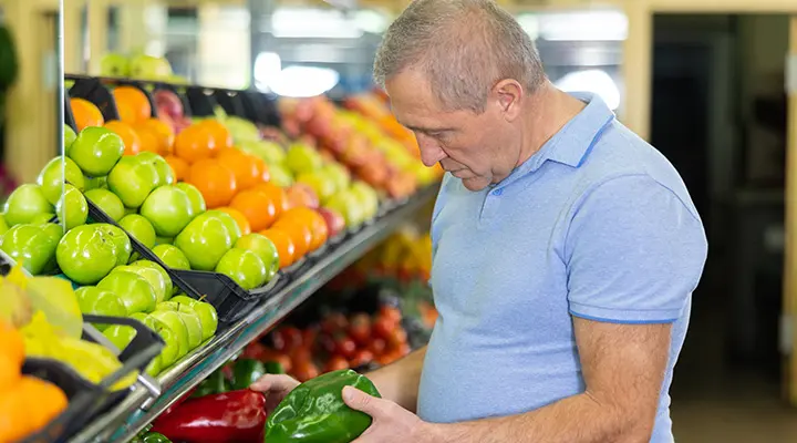 Hombre comprando verduras.