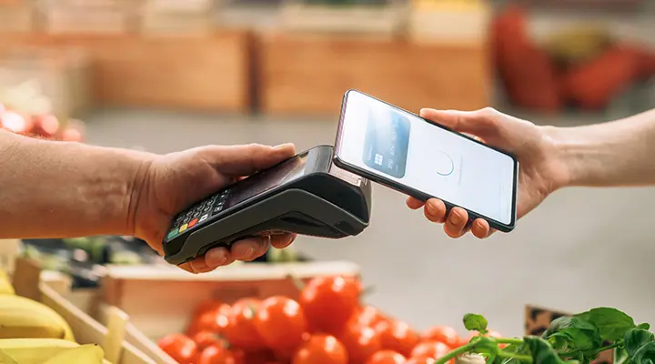 Persona pagando en supermercado.