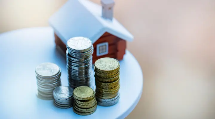 Alquiler de vivienda, imagen con una casa y monedas.