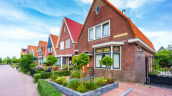 Rij klassieke Nederlandse huizen langs een nette straat in een woonwijk
