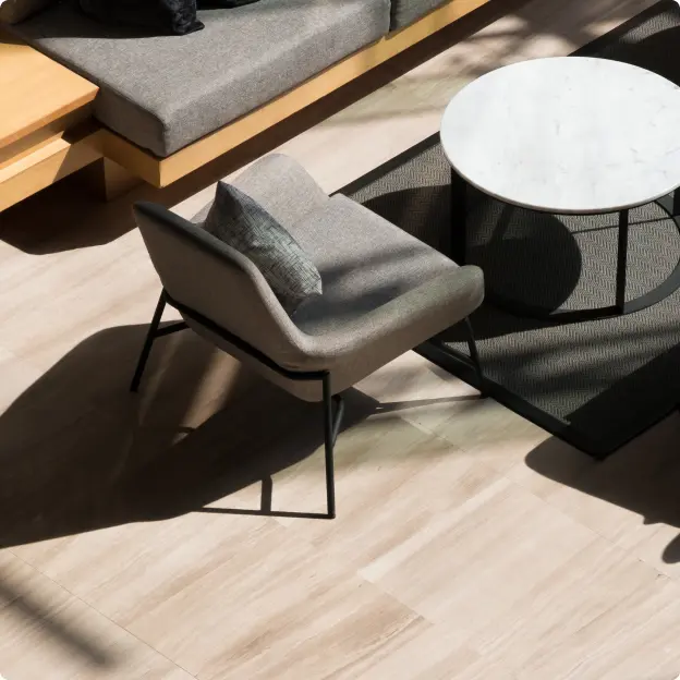Bild eines leeren Stuhls an einem kleinen Tisch neben einem Sofa.