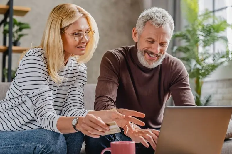 shutterstock_1748857703_resized.jpg People smiling while looking at the laptop