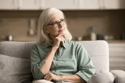 Woman sitting on couch thinking