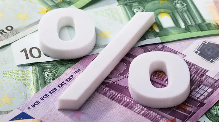 Groot wit procentteken geplaatst boven verspreide eurobiljetten.