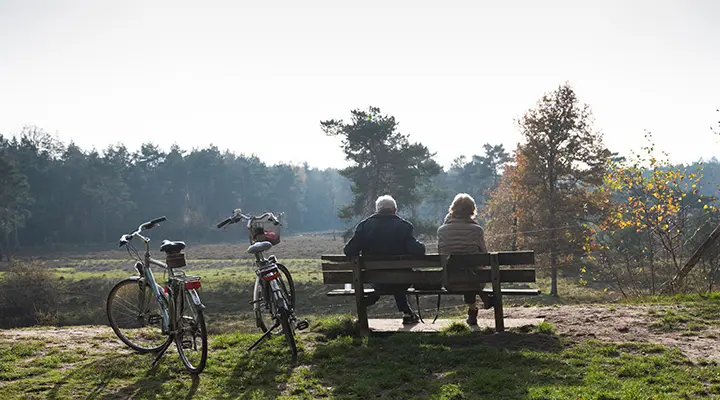 Ouder echtpaar op bankje met fiets