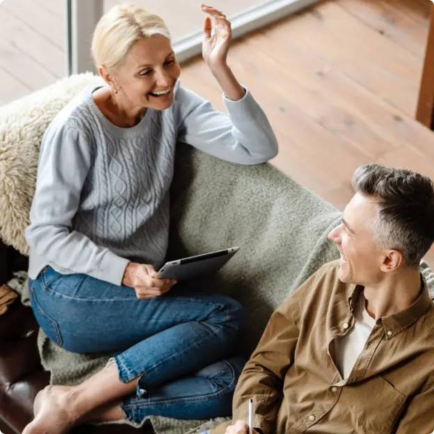 Para w średnim wieku rozmawia siedząc na kanapie