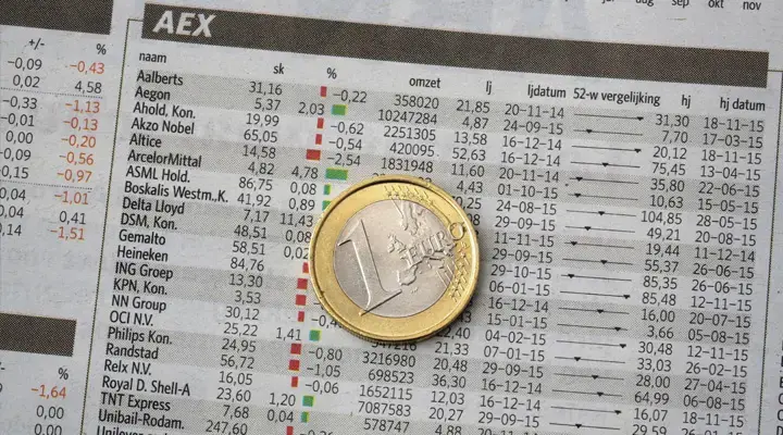 Periódico con las bolsas europeas y moneda de un euro.