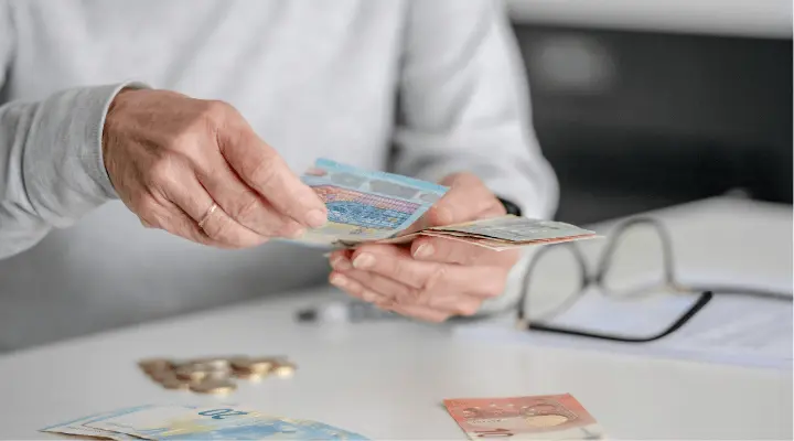 Mano contando billetes que representa la rentabilidad de los bonos del estado a 3 años.