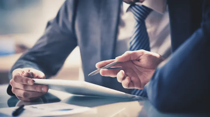 Dos personas con ipad, van vestidas con traje de chaqueta.