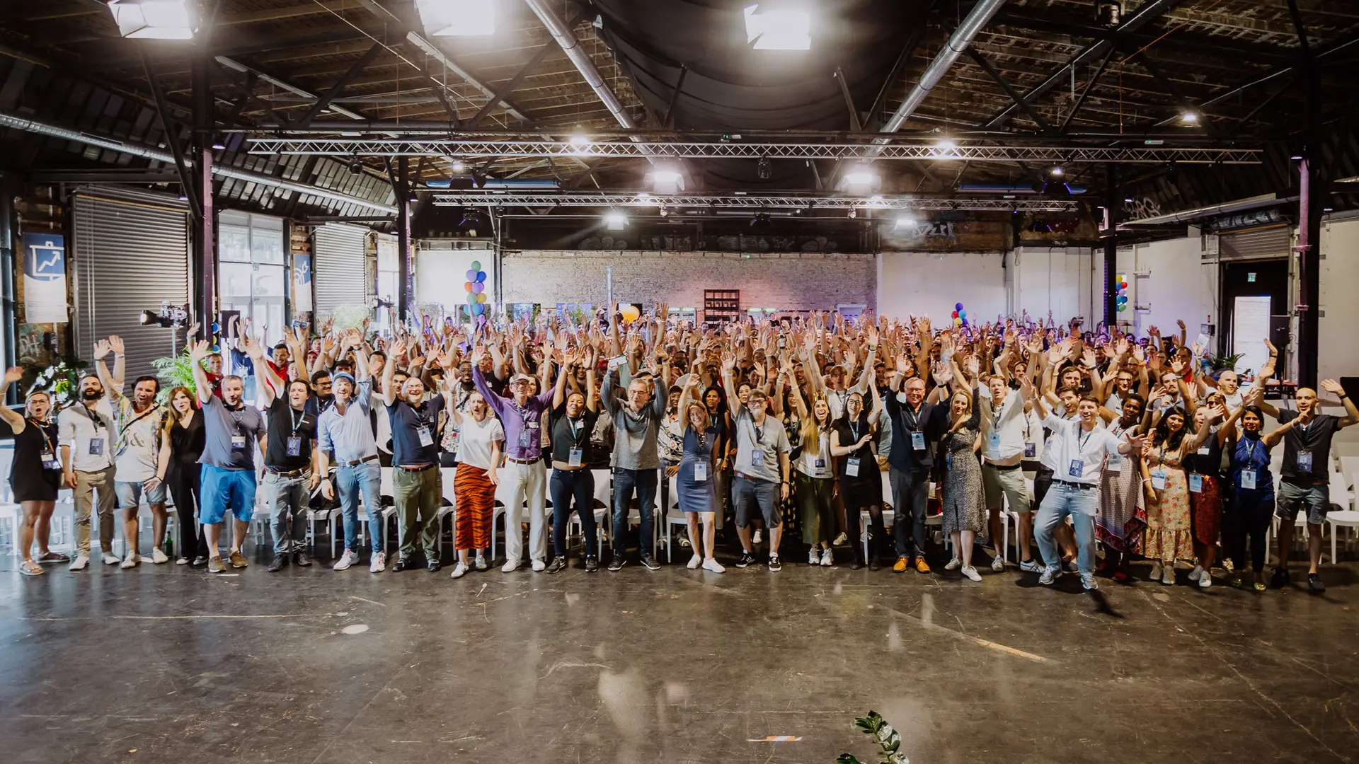 Raisin COM - Group Picture of Staff.jpg Wide group photo of several hundred Raisin employees in a large hall, standing in rows with their arms raised, smiling towards the camera.