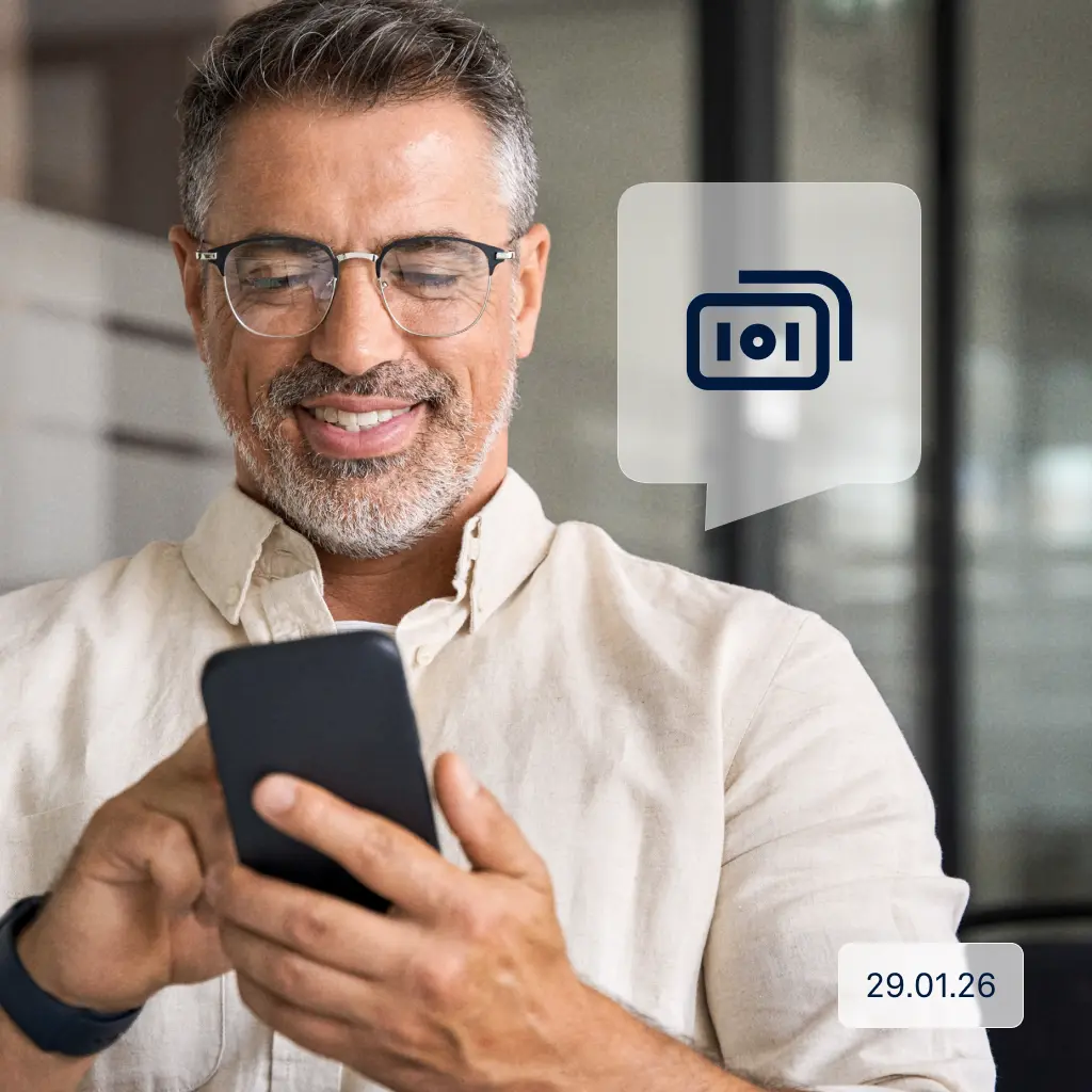 Raisin DE SEPA Instant Payments Ein Mann mittleren Alters steht in einem modernen Büro und schaut lächelnd auf sein Smartphone. Neben ihm ist ein Symbol für eine Sofortüberweisung zu sehen, unten rechts steht das Datum 29.01.26.